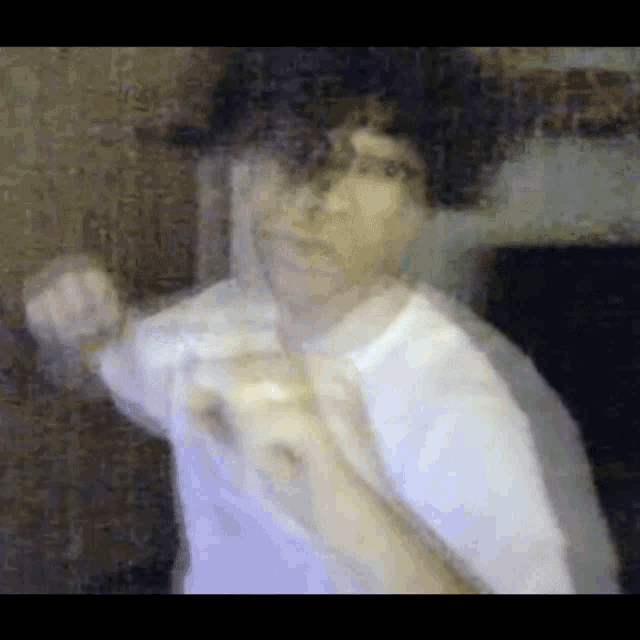 a blurry picture of a man in a white shirt pointing