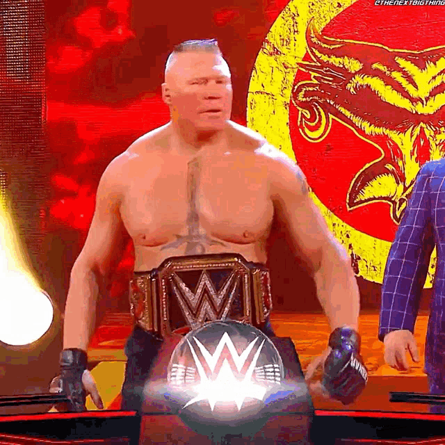 a man without a shirt is wearing a wrestling championship belt