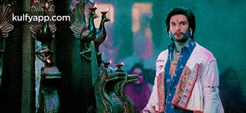 a man is standing in front of a statue of a peacock in a room .