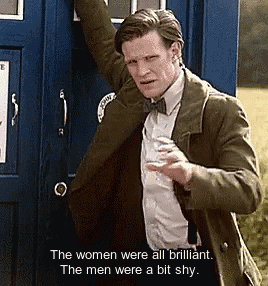 a man is standing in front of a blue box that says the women were all brilliant the men were a bit shy .