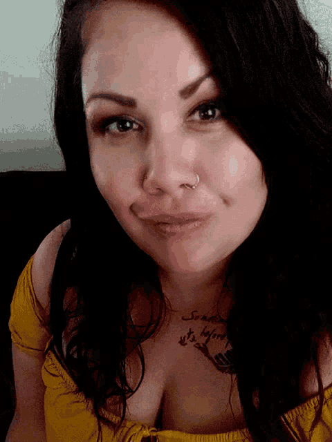 a woman wearing a yellow top has a tattoo on her chest that says summer