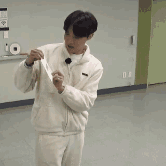 a man in a white sweater is holding a sign that says bts