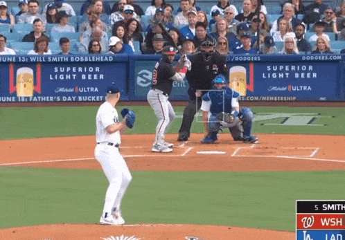 a baseball game is being played in front of a banner that says superior light beer