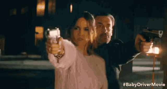 a man and a woman are pointing guns at each other in a baby driver movie scene