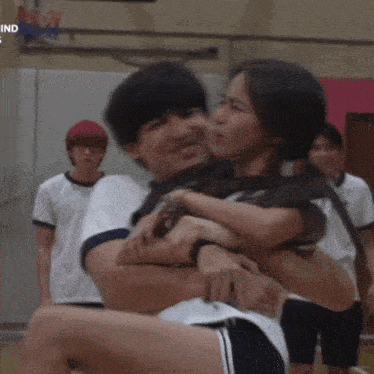 a man is carrying a woman on his shoulders in a gym ..