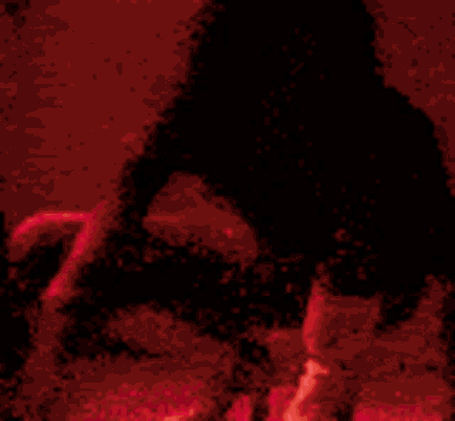 a red background with a shadow of a person holding something