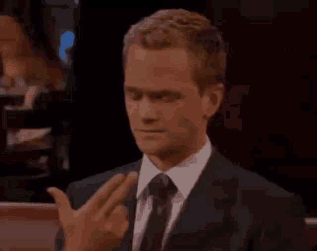 a man in a suit and tie is making a middle finger gesture
