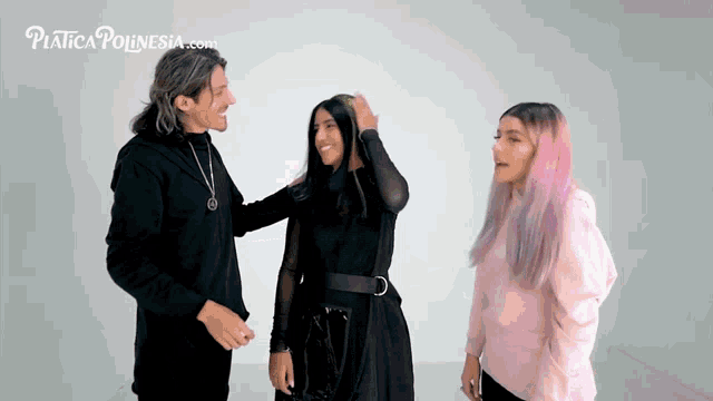 a man and two women are standing in front of a white wall with the website piatica poinesia.com on the bottom