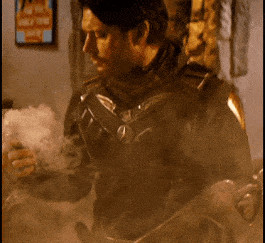 a man in a superhero costume is holding a glass in his hand .