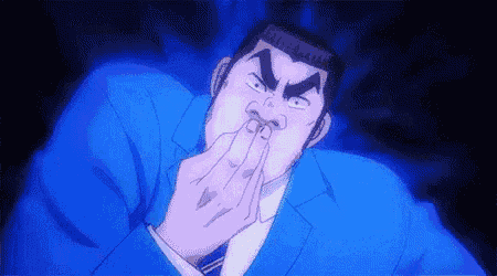 a man in a blue suit and tie is covering his mouth with his hand .