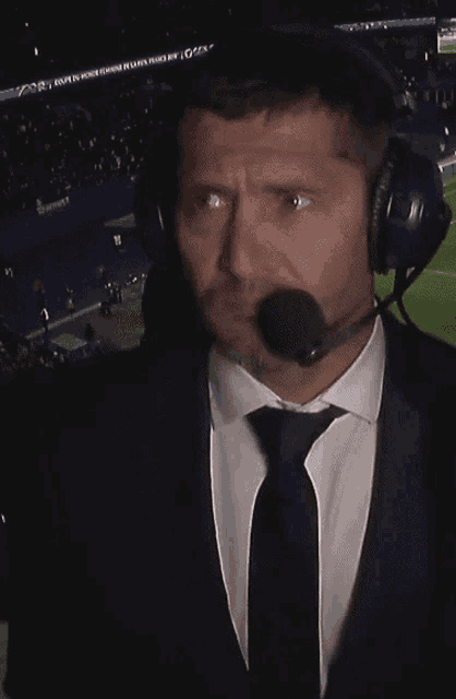 a man in a suit and tie is wearing a microphone