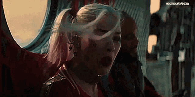 harley quinn from the movie suicide squad is sitting in a plane with a man .