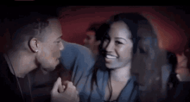 a man and a woman are holding hands in a movie theater .