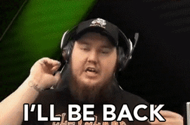 a man wearing headphones is saying `` i 'll be back '' while talking on a cell phone .