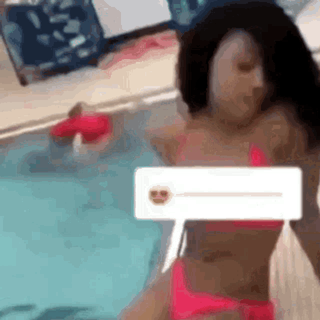 a woman in a pink bikini is swimming in a pool .