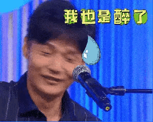 a man is singing into a microphone with chinese writing on the background