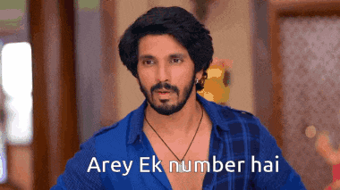 a man with a beard is wearing a blue shirt and a necklace and says arey ek number hai