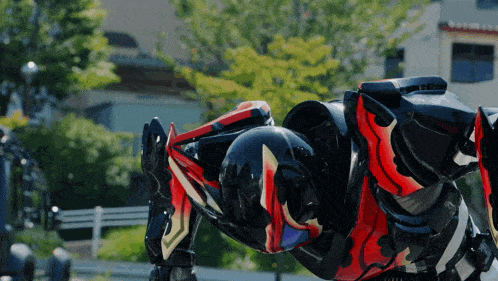 a black and red robot is crawling in the grass