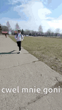 a person is running down a sidewalk with the words twel mnie goni written on it