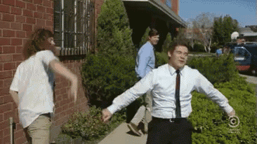 a man in a suit and tie is running with his arms outstretched .