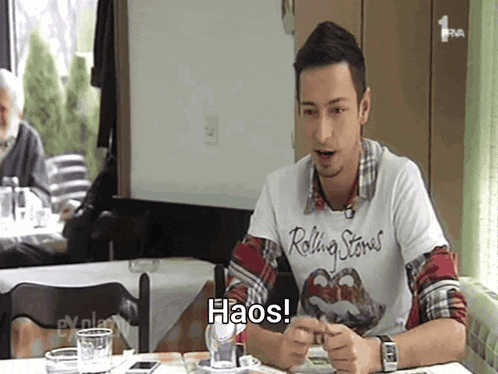 a man wearing a rolling stones t-shirt says haos