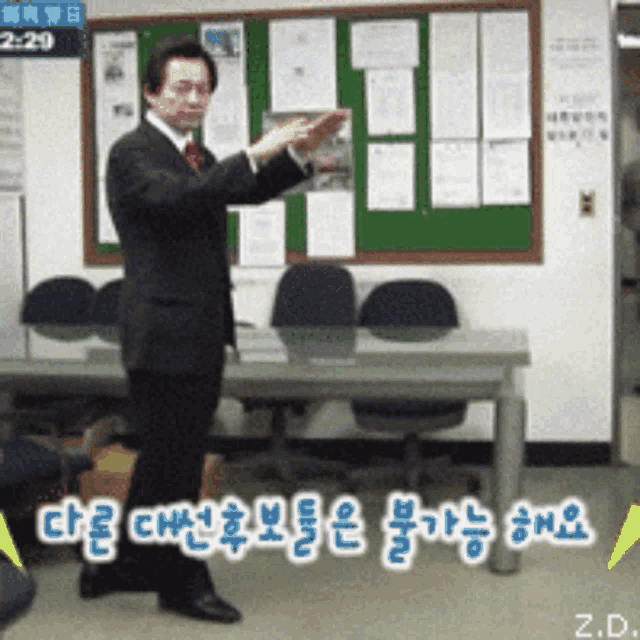 a man in a suit and tie stands in front of a bulletin board that says 2:28
