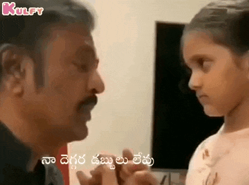 a man is talking to a little girl in a room in a foreign language .