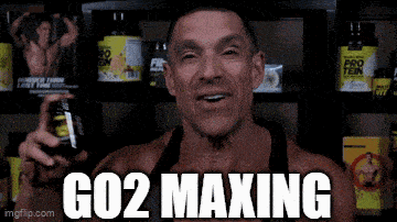 a man holding a bottle of co2 maxing in front of a shelf of supplements