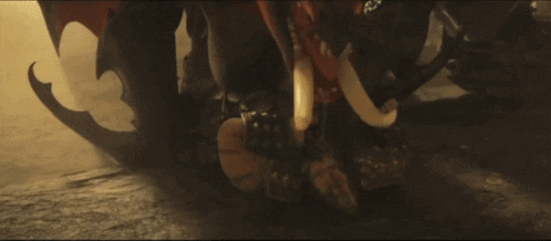a close up of a person laying on the ground with a dragon in the background
