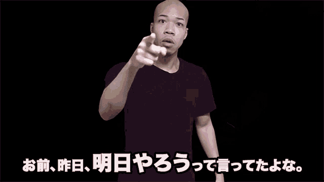 a man in a black shirt is pointing at something in a black background