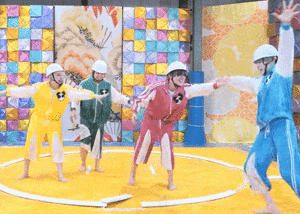 a group of people are standing in a circle with their arms outstretched on a yellow mat