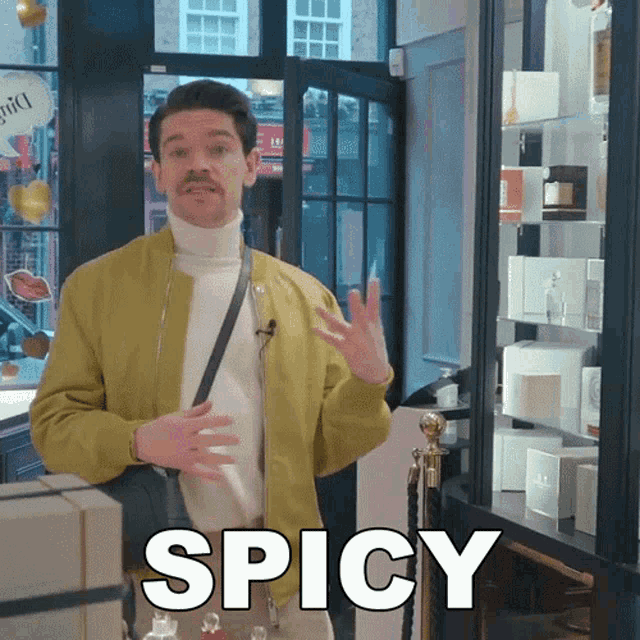 a man in a yellow jacket says spicy in front of a window