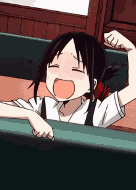 a girl is yawning while sitting at a table with her mouth open