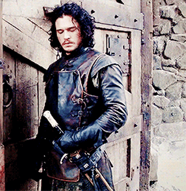 a man in a leather jacket holding a sword
