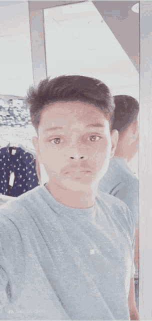 a young man taking a selfie with his back to the camera