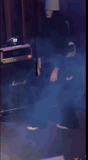 a person dancing in front of a marshall amp