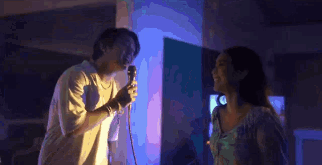 a man and a woman are dancing in front of a television