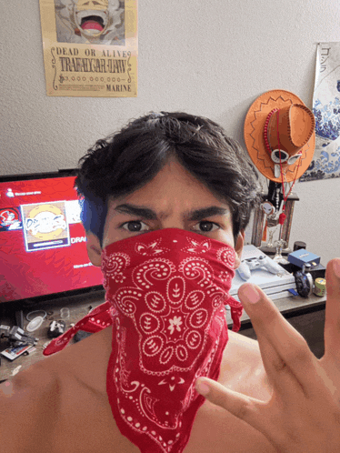a man wearing a red bandana has a poster behind him that says dead or alive