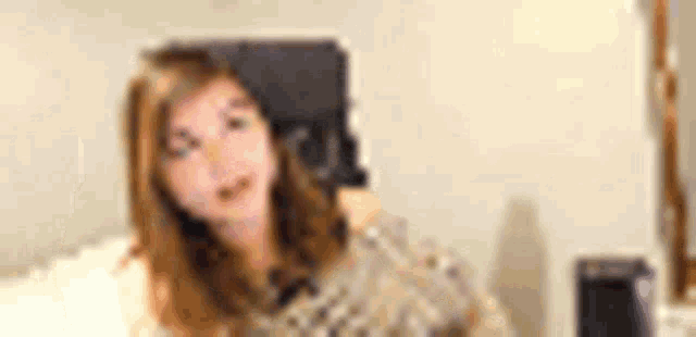 a blurry picture of a woman sitting in a chair in a living room .