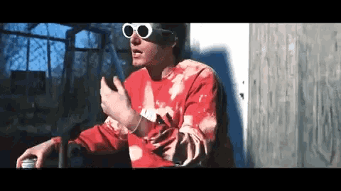 a man wearing sunglasses and a red shirt that says ' nike ' on it