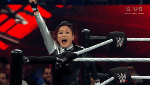 a woman in a wrestling ring with the letters w on her gloves