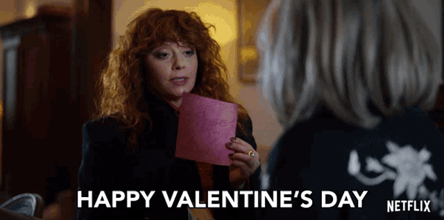 a woman holding a piece of paper that says happy valentine 's day on it
