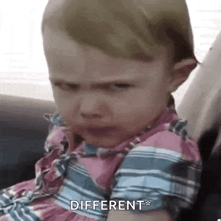 a baby girl is crying and making a funny face while sitting in a chair .