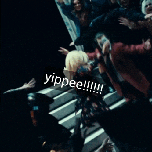 a group of people are dancing in a dark room with a sticker that says yippee !!!