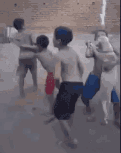 a group of young men are dancing in front of a brick building .