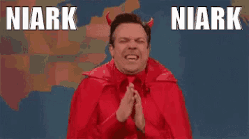 a man in a red devil costume is praying with his hands folded .