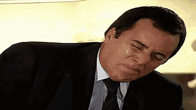 a man in a suit and tie is making a funny face