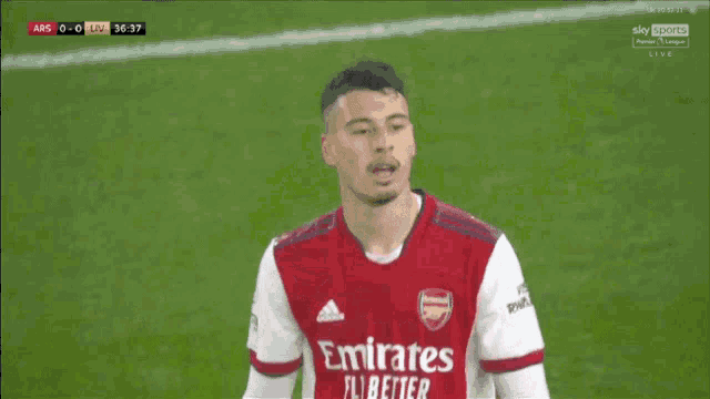 a soccer player is wearing a red emirates fly better shirt