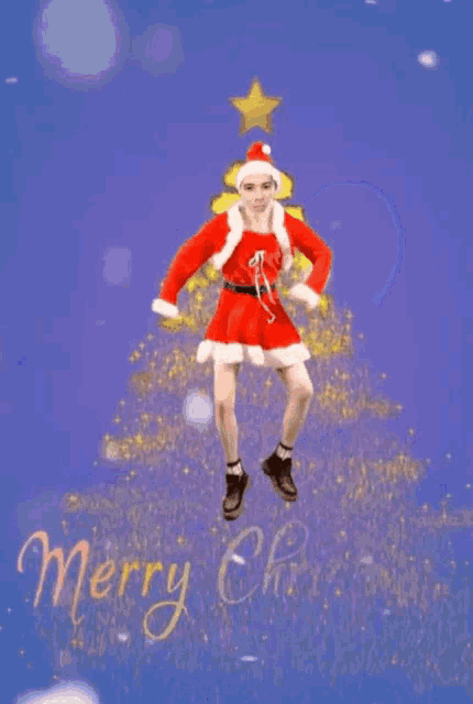 a person dressed as santa claus is dancing in front of a christmas tree and says merry christmas .