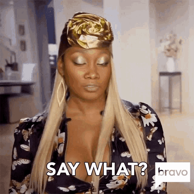 a woman wearing a gold headband and a plunging neckline is saying say what .